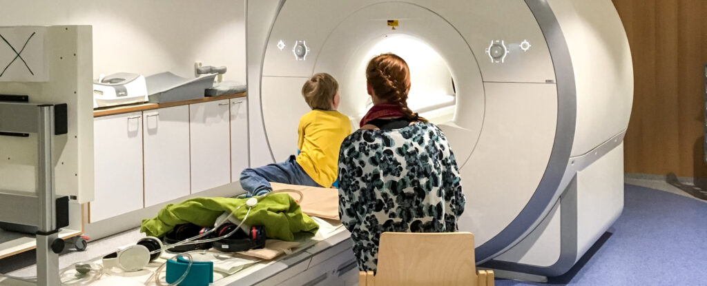 Viisivuotiaiden lasten MRI-käyntejä varten tehdään etukäteen valmisteluja, jotka on suunniteltu lapsille ja perheille sopiviksi. Kuvassa lapsi siirtyy MRI-kameraan kuvantamista varten. Kuva: Susanne Sinisalo. 